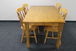A pine farmhouse style kitchen table fitted with two drawers together with a set of four chairs