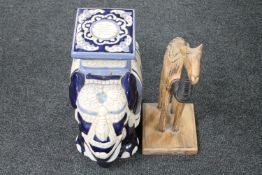 A pottery elephant plant stand and a wooden figure of a camel