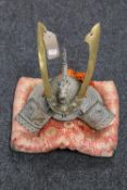A Japanese brass samurai presentation helmet on cushion, presented from Yokkaichi Port Authority,