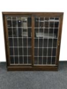 An oak leaded glass sliding door bookcase