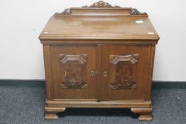 A 20th century continental oak double door cabinet with walnut panelled doors