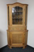 A blond oak leaded glass door corner display cabinet