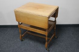 An oak two tier flap sided trolley
