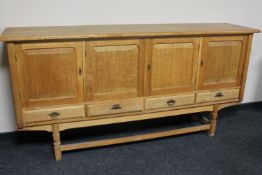 A blonde oak four door sideboard