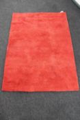 A contemporary red woollen rug