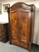 A walnut dome top double wardrobe,