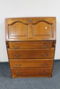 An oak writing bureau fitted four drawers beneath