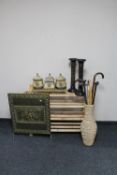 A set of pine open shelves together with a wicker vase containing walking sticks,
