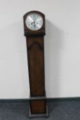 An oak cased granddaughter clock with silvered dial and key