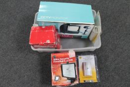 A plastic crate containing CCTV camera and monitors, two motion sensor floodlights,