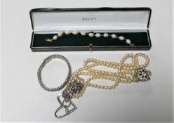 A bag of simulated pearl necklaces and a silver necklace