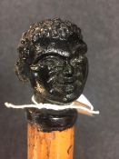 An unusual nineteenth century malacca walking cane with green glass knop terminal modelled as a