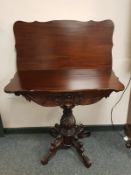 An Edwardian mahogany carved tea table on pedestal support