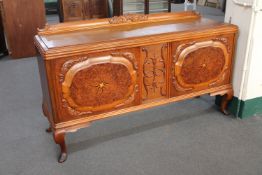 An early 20th century oak sideboard on cabriole legs