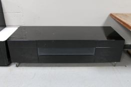 A contemporary high gloss entertainment stand fitted four drawers