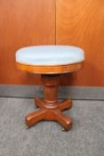 An antique oak adjustable stool on castors