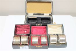Four boxed pairs of silver serviette rings