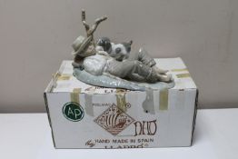 A Nao china figure : A Young Boy Sleeping by a Tree with a Puppy, height 15 cm, length 25 cm.