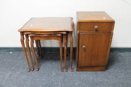 A nest of three mahogany glass topped tables together with an oak pot cupboard