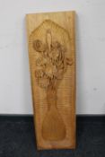 A carved oak wall panel depicting flowers in a vase