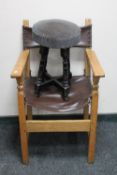An oak leather slung upholstered armchair together with a pub stool