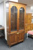 An Edwardian oak double door glazed bookcase fitted cupboard beneath