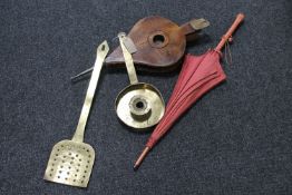 A large brass candle stand together with coal shovel together with a vintage wooden bellow and a