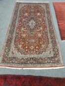 A Kashan carpet on red ground,