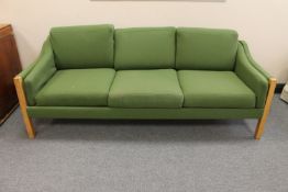A twentieth century blond oak framed three seater settee upholstered in green fabric