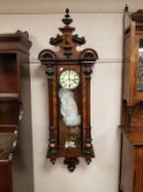A Victorian wall clock with enamelled dial, with pendulum and weights,