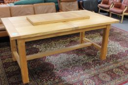A contemporary oak extending dining table with leaf