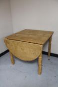 A blonde oak flap sided dining table