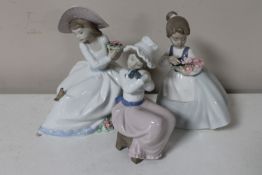 Three Nao figures; girl seated with flowers,