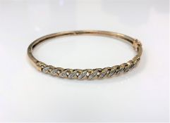 A 9ct gold diamond set hinged bangle CONDITION REPORT: 8.