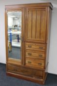 An Edwardian mahogany compactum wardrobe with mirror door