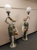 A pair of marble floor lamps modelled as maidens holding flowers,