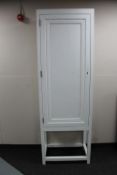 A painted pine single door cupboard on raised legs