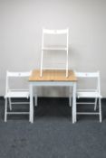 An Ikea kitchen table and three folding chairs