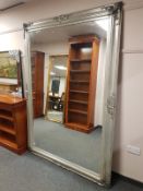 A contemporary silvered leaning mirror,