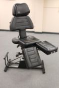 A black stitched vinyl adjustable tattooists chair
