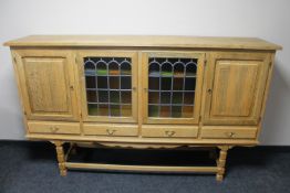 A continental light oak glazed sideboard