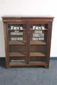 An Edwardian mahogany display cabinet bearing advertising