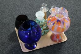 A tray of four coloured glass vases and a pair of glass candlesticks