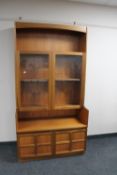 A mid twentieth century teak double door glazed bookcase fitted with cupboards beneath