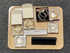 A tray of silver and plated dress bangles and bracelets,