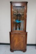 A mahogany corner display cabinet with astragal glazed door