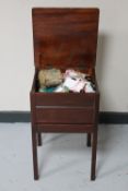 A mahogany sewing box on raised legs fitted with a drawer containing a large quantity of sewing