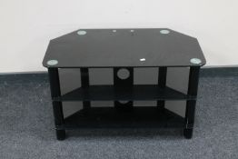 A black glass three tier TV stand and an oak corner cupboard