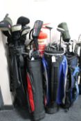 Four golf bags containing assorted irons and drivers