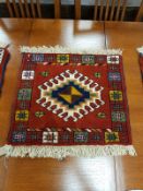 A Caucasian fringed mat on red ground 55 cm x 55 cm